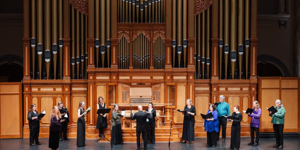 Choir members sing in front of a grand old pipe organ in one of Adelaide's historic churches.